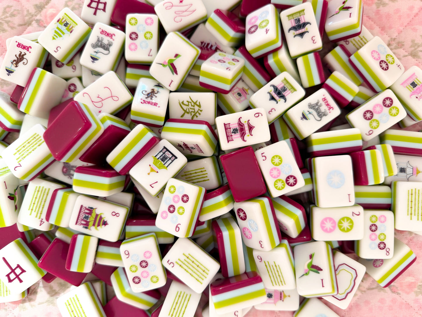 Collection of colorful game tiles with various designs on a plum and chartruse background