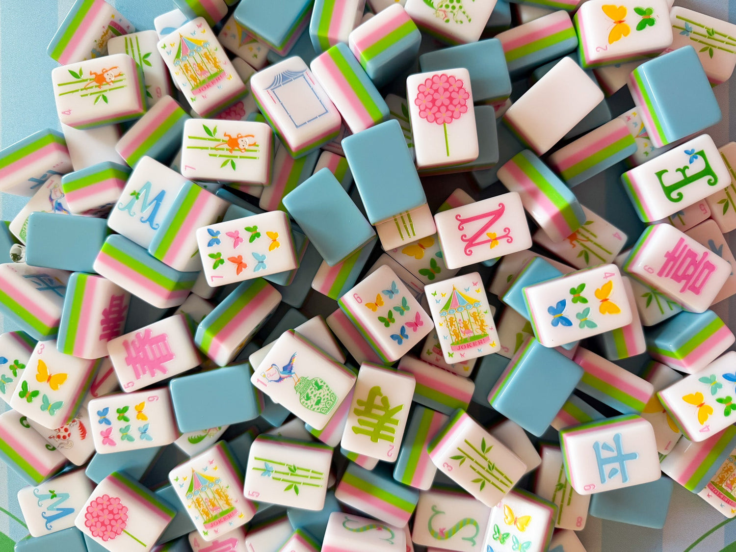 Colorful miniature tiles with various designs and letters on a blue background
