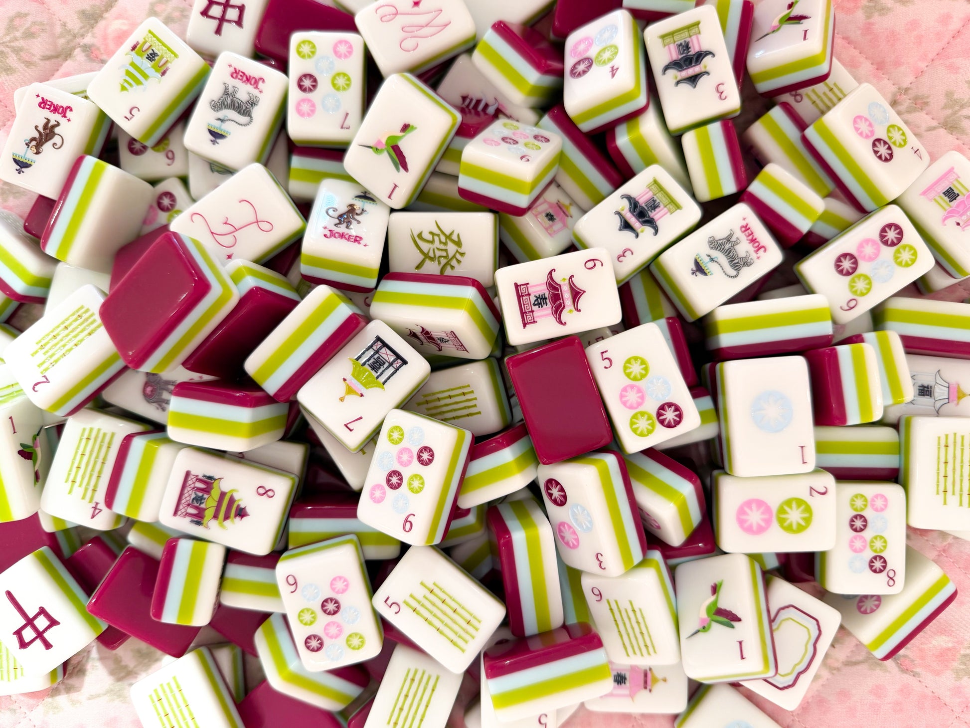 Collection of colorful game tiles with various designs on a plum and chartruse background